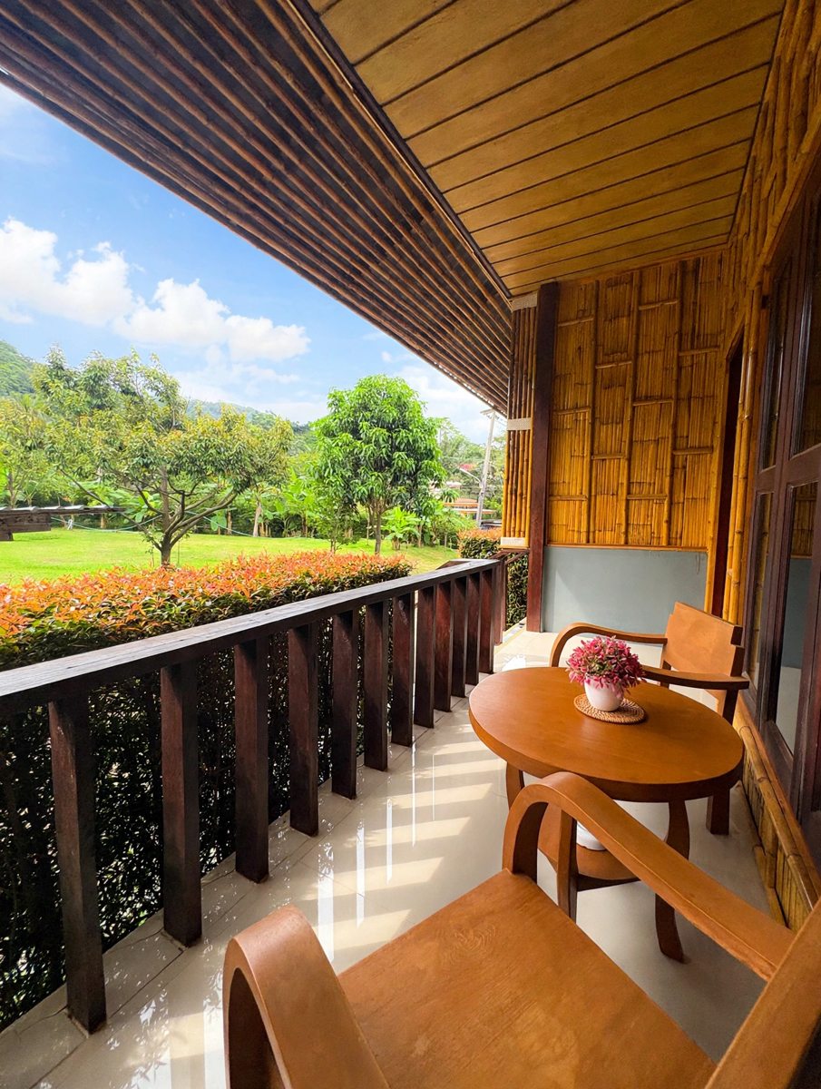 Private wooden balcony with chairs and garden view