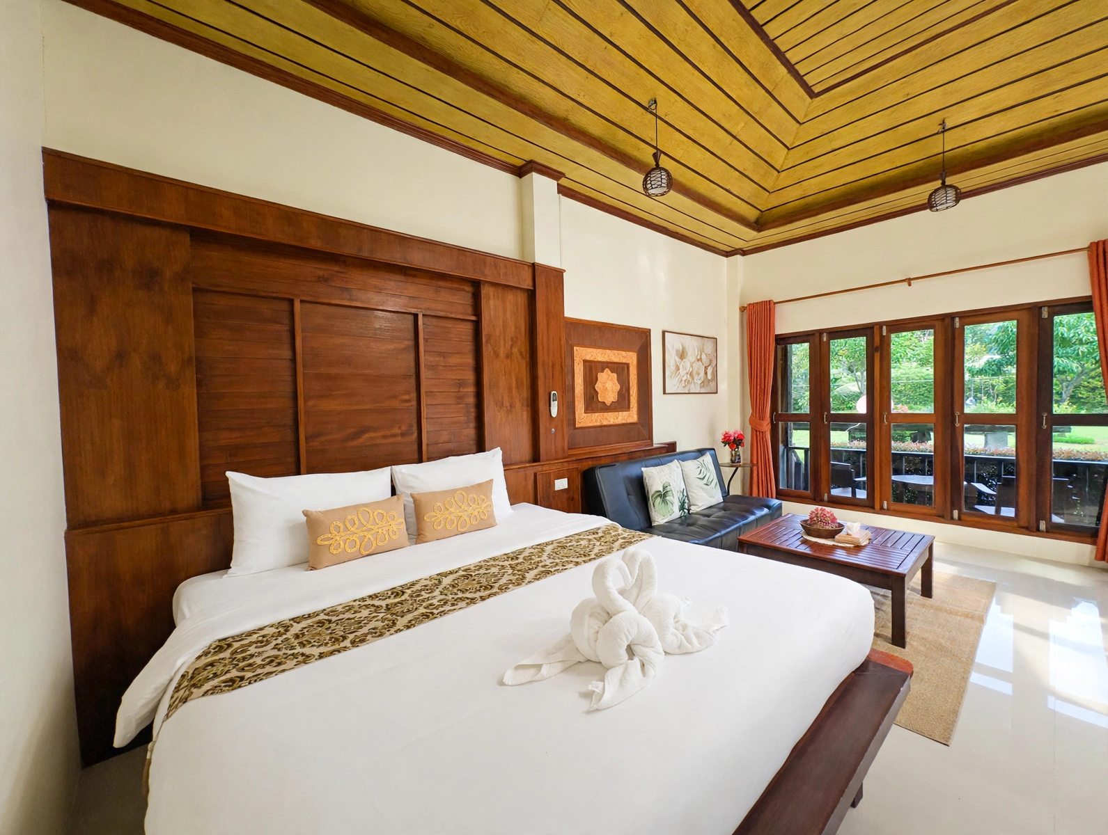 Standard Double Room with bed, sofa and garden-facing windows